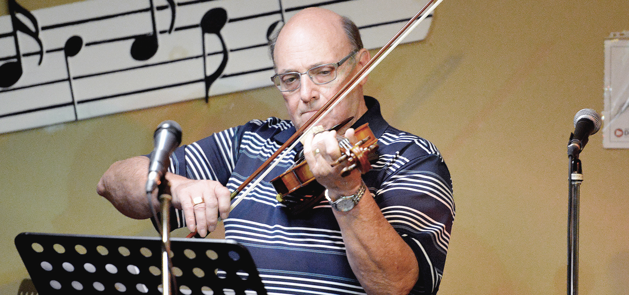 C'est un monsieur retraité qui jouent du violon sur scène lors du spectacle organisé par Musique O Max.