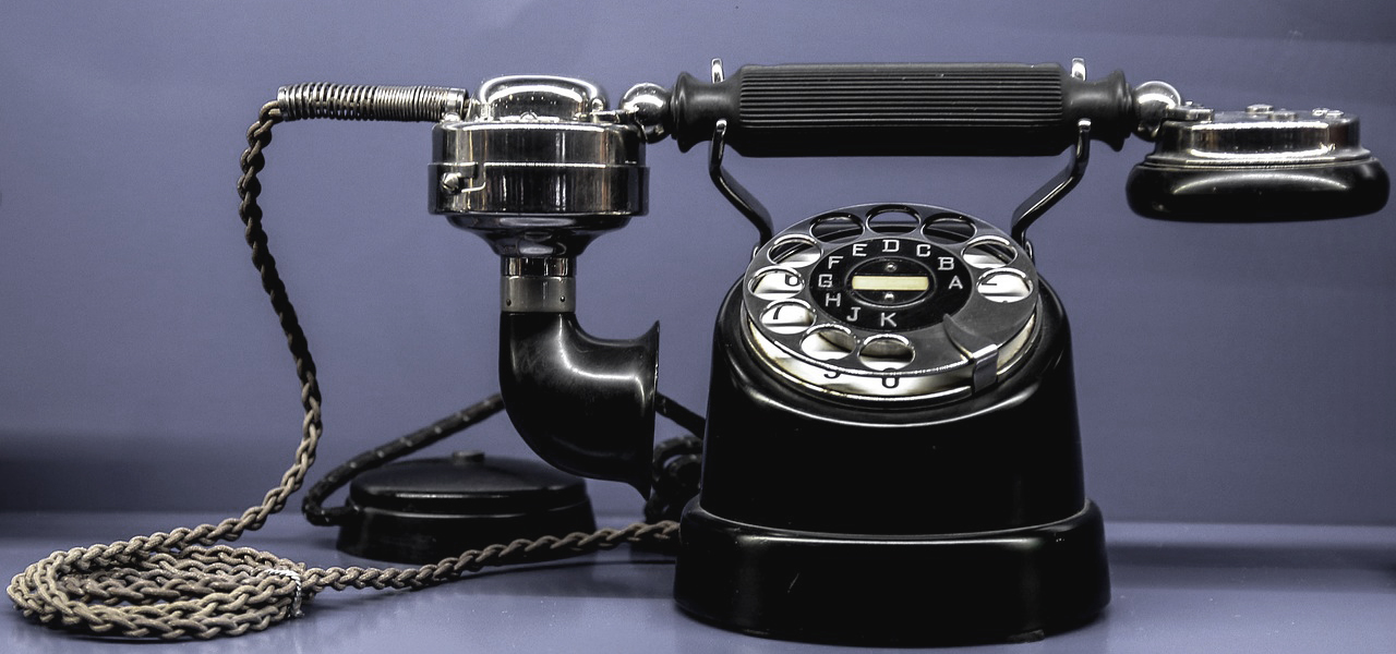 Photo d'un très vieux téléphone avec un cadran rond qui tourne pour composer un numéro de téléphone.