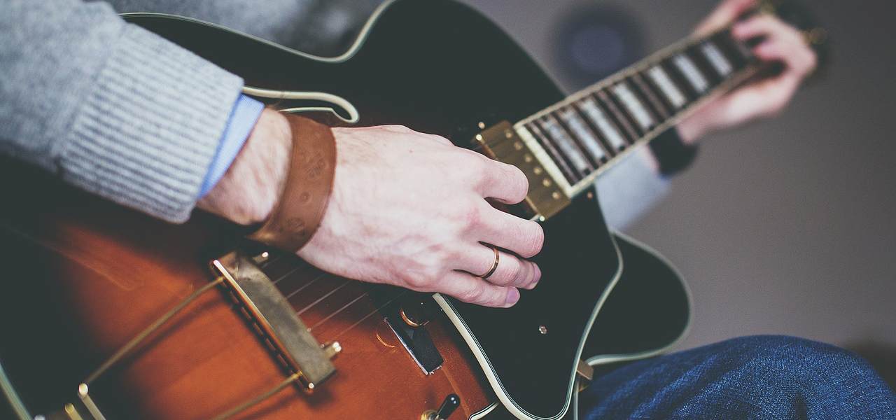 Gros plan sur une guitare avec la main d'une personne.